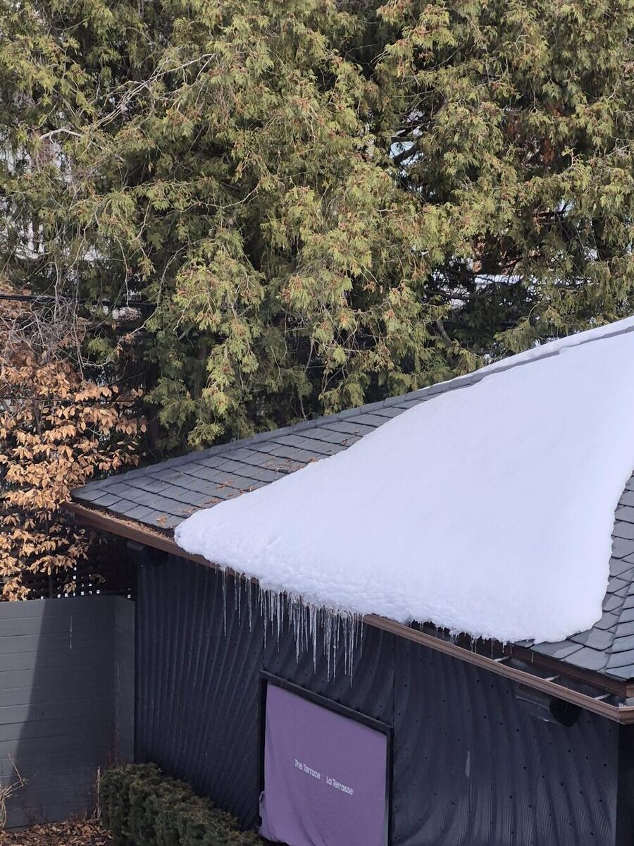 Large icicles hanging from a snow-covered roof edge
